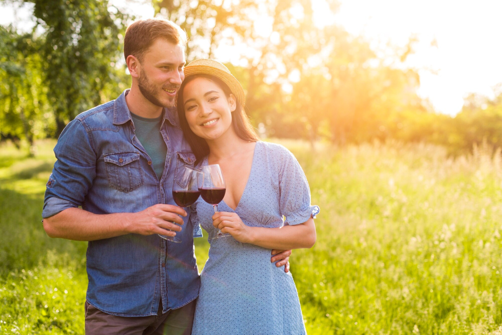 Couple trinquant avec un verre de vin lors d’un rendez-vous romantique près de Dijon, rencontre organisée via l’application Jecontact